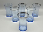 DEMI CRISTAL - Jogo de 6 copos em demi cristal azul com elegante perfil curvo (tipo sabre/cinturado) e delicada borda prateada acompanhada de friso logo abaixo. Marcas do tempo e de uso.
