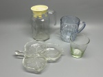 DEMI CRISTAL - Lote composto por: Jarra de vidro transparente com tampa amarela, caneca de vidro azulada com relevo texturizado, copo de vidro transparente com base esverdeada e gravação "Ca' d'Oro", e petisqueira em vidro transparente modelada em formato de três folhas agrupadas.