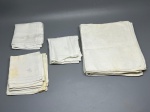 CAMA - MESA - BANHO - Lote de 14 peças enxoval de mesa vintage em tecido branco, composto por toalhas e guardanapos de linho ou algodão fino, detalhados com bordados à mão de monogramas (iniciais) e barras com ponto ajour, apresentando marcas do tempo e manchas amareladas.