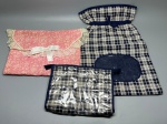 CAMA - MESA - BANHO - Kit com três organizadores em tecido: composto por uma bolsa tipo envelope matelassê em tom rosa com estampa floral miúda, acabamento em renda e laço decorativo frontal; um saco organizador em tecido xadrez azul-marinho e branco com fechamento por cordão ajustável e visor transparente; e uma necessaire/bolsa com zíper e visor plástico transparente na mesma padronagem xadrez. Marcas do tempo e de uso.
