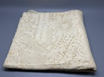 CAMA - MESA - BANHO - Toalha de mesa (300x170 cm) integralmente confeccionada em rica renda de tom claro, com tramas elaboradas em motivos florais e ornamentais sobre fundo geométrico. A peça apresenta marcas do tempo e manchas amareladas de guarda.
