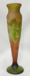 ÉMILE GALLÉ (FRANÇA, Circa 1900). - Belíssimo vaso em pasta de vidro francês nas cores verde, marrom e ocre, decorado com orquídeas e folhagens em relevo. Vaso assinada "Gallé" no bojo. Medidas: 23 x 06.8 cm.