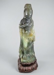 CHINA, DINASTIA QING, SÉC. XVIII/XIX (ou anterior) - Muito rara escultura chinesa de deusa GUANYIN (Bodhisattva) de ENORMES PROPORÇÕES, esculpida a mão em bloco único de Jade em dois tons. Estrutura robusta, vestes fluidas, postura hierática, uma das mãos junto ao peito em gesto ritual. Altura: 57 cm. Base de madeira original em madeira esculpida à mão com pétalas de Lotus invertida. Altura total 66 cm. PESO: 15 KG