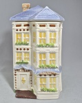 WEISS/ AVON - COLEÇÃO 'TOWNHOUSE CANISTER' - Biscoteira em cerâmica policromada no formato de casa vitoriana. Marca na base. Década de 80. Discreto fio de cabelo na quina do telhado. Med. 29.5 x17x16 cm.