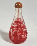 CHINA, DINASTIA QING, SÉC.XIX/XX - Antigo snuff bottle em Peking glass em vermelho overlay, decorado com cena folclórica e árvore de sabugueiro. Tampe esculpida em pedra do Sol e colher em marfim tingido. Med. 8 cm. Pequeno trincadinho na borda.
