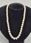 Colar chinês em pérolas esféricas, fecho com ideograma auspicioso de prosperidade e alegria em metal dourado. Med. aberto, 46 cm (C).