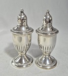 Par de polvilhadores em vidro e Prata de lei Sterling. Um dos vidros está com a borda lascada. Med: 12 x 5 cm.