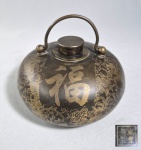 CHINA, DINASTIA QING, marca e do período Xianfeng (1851-1861) -  Antigo aquecedor de mãos ou frasco de água chinês em latão, decorado com o caractere chinês "Fu" (significando bênção ou boa sorte), motivos florais dourados e texto do 'Min Nong' - "Comiseração pelo Lavrador", escrito pelo poeta Li Shen durante a Dinastia Tang. Tradução poética em Português: "Capinando sob o sol ardente do meio-dia, o suor pinga na terra sob as plantas de cereais. Quem pensa que, na comida servida ao prato, cada grão carrega tanto suor e sacrifício?". Marca do reinado no fundo.  Med. 13 x 9 x 12 cm ( com a alça levantada).  ----- https://www.invaluable.com/auction-lot/chinese-qing-dynasty-inlaid-copper-hand-warmer-184-c-ec3435fbd4
