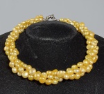 Elegante colar 'Torsade' com fios de pérolas verdadeiras em tom dourado, fecho tipo boia folheado a ouro branco. Med. 41cm.