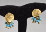 Par de brincos de pressão folheados a ouro com pendantes de contas facetadas na tonalidade turquesa, medindo 2,5cm.