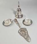 Lote com itens em metal banhado a prata, sendo: Sineta de mesa, duas pequenas mantegueiras em vidro com pratinhos e uma espátula de doces. Possuem desgastes. Medida maior: 19.5 cm.