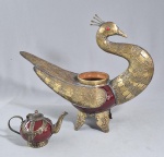 Exótica floreira no formato de pavão, confeccionada em metal dourado e bojo em cerâmica vitrificada na tonalidade vermelha, med. 35 x 27 x 14 cm e pequeno bule decorativo em cerãmica vermeljo bordô, com guarnição em metal cinzelado. Med. 14 x 08 x 08 cm.