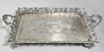 BRASIL, Séc.XIX/XX - Antiga bandeja tabuleiro em metal branco, fundo cinzelado, galeria cinzelada com folhagens, flores e volutas. Pés em garra. Sem contraste visível. Med. 37 x 18 x 5 cm. Desgastes no banho.