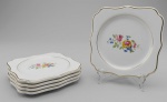 Lote com cinco pratinhos quadrados em porcelana decorados com flores ao centro. Marca no verso. Med. 14 x 14 cm.