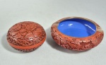 Lote com duas peças em Laca chinesa vermelho cinnabar, sendo uma caixinha e um cinzeiro com interior decorado com esmalte azul. Med. 10 x  3.5 cm e 7 x 3.5 cm. Obs: caixinha com fio de cabelo.