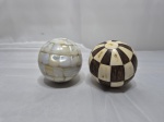 Par de bolas decorativas, sendo uma revestida de lâmina de osso e uma com lâmina de madrepérola. Medindo aproximadamente 7,5cm de diâmetro.