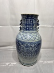 Vaso de porcelana chinesa decorado em azul e branco sob o vidrado, apresentando ornamentação floral densa, faixas geométricas e caracteres estilizados de dupla felicidade (Shuangxi), com par de alças aplicadas no gargalo. Medindo 13cm de boca x 17,5cm de base x 39cm de altura. Peça com abertura na base para abajur.