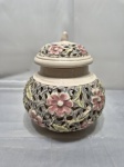 Compoteira bojuda em porcelana vazada com flores em relevo. Medindo 14cm de bojo x 12cm de altura.