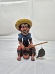 Enfeite na forma de pescador em cerâmica com policromia. Medindo 18cm de altura. Com pequenos bicados.