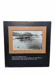 Arquivo Geral da Cidade do Rio de Janeiro | Estrutura em madeira que porta 2 impressões fotográficas históricas do Rio de Janeiro — Canal do Jardim de Alah e Avenida Delfim Moreira, uma em cada lado, com legendas explicativas. Marcas do tempo. -dim- 70x70x4cm.