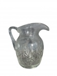 Encantadora jarra em cristal com rica decoração em relevo, de aspecto refinado — peça que combina funcionalidade e beleza com maestria. Marcas do tempo. -dim- 18cm A.