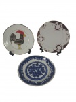 Lote composto por 3 pratos de sobremesa de origens distintas: um produzido em esteatita, um em Porcelana Real SP e um com marcação japonesa — conjunto eclético e decorativo. Marcas do tempo. -dim- 19cm D.