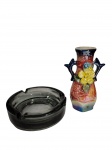Lote composto por vasinho de porcelana estilo ânfora e cinzeiro redondo de vidro cinza. -dim- Vasinho 11cm A. Cinzeiro 10cm D.