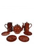 Conjunto de cerâmica esmaltada composto por 4 pires, 1 bule e 2 leiteiras. Apresentam bicados conforme fotos. -dim- pires 13cm D; leiteiras 16cm A.