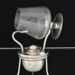 METAL PRATEADO, um (1) suporte para aquecer taça de conhaque, sem marca de manufatura aparente, acompanha taça de pé baixo, confeccionada em vidro, incolor e translúcida, ideal para coleção de bar, altura total com a taça 18 cm, vide foto.