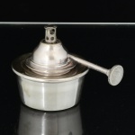 METAL PRATEADO, um (1) queimador com tampa rosqueável, punção não identificado representando a letra M, medindo 7 cm diâmetro mais a haste, vide foto.