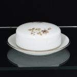 PORCELANA, uma (1) manteigueira com tampa e presentoir, ornada com rosas, tom sir tom, detalhes prateados, modelo MEDAILLON, manufatura RENNER (Porto Alegre, RS, fundada em 1942; em 1998 foi vendida para a Vista Alegre de Portugal; em 1999 mudou a razão social para Vista Alegre do Brasil), medindo 17 cm diâmetro, vide foto.