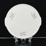 PORCELANA, um (1) medalhão para torta ou bolo, ornamentação policromada representando discos desparelhados em um fio, arremates com frisos a ouro, marca RENNER (Porto Alegre, RS, fundada em 1942; em 1998 foi vendida para a Vista Alegre de Portugal; em 1999 mudou a razão social para Vista Alegre do Brasil), medindo 27,5 cm diâmetro, vide foto.