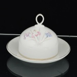 PORCELANA, uma (1) manteigueira com tampa e presentoir acoplado, ornamentação floral policromada, arremates com frisos a ouro, marca STEATITA (Campo Largo, PR, funcionou de 1954 a 1994), medindo 15 cm diâmetro, vide foto.