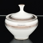 PORCELANA, um (1) açucareiro com tampa, tonalidade branca, detalhes prateados com barrado grego, marca MAUÁ (Mauá, SP, 1937 a 1968), medindo 10 cm altura, vide foto.