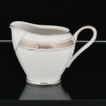 PORCELANA, uma (1) cremeira, tonalidade branca, detalhes prateados com barrado grego, marca MAUÁ (Mauá, SP, 1937 a 1968), medindo 8 cm altura, vide foto.