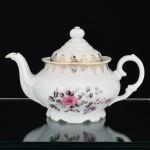 PORCELANA, um (1) bule de chá com tampa, ornado com rosa em policromia, barrado vegetalista a ouro, marca SCHMIDT (Pomerode, SC; Mauá, SP; Campo Largo, PR, fundada em 1945, ainda em atividade, maior fábrica de porcelana da América Latina), medindo 15,5 cm altura, vide foto.