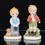 ESCULTURAS, duas (2) figurativas representando menino e menina, confeccionadas em biscuit, pintadas a mão em policromia, uma delas quebrada e colada, sem marca de manufatura aparente, medindo em média 11 cm altura, ideais para coleção de bibelôs, vide foto.