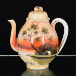 PORCELANA JAPONESA, um (1) bule para café, ornamentação pintada a mão em policromia, representando paisagem lacustre com casebre, marca representada pela letra H dentro de losango e os caracteres: acima Ni  Pon (Japão), abaixo produzido em Kutani, arremates a ouro com sinais de desgastes, medindo 20 cm altura, vide foto.