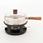 DIVERSOS, uma (1) panela para fondue, confeccionada em aço inox, pega da tampa e cabo em madeira torneada, acompanha trempe em ferro esmaltado com sinais de oxidação, além de queimador e apagador, medindo 17,5 cm diâmetro, vide foto.
