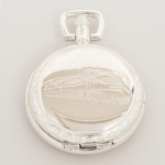 RELÓGIO, um (1) de algibeira (bolso), CÓPIA de relógio antigo, mostrador com algarismos arábicos e a legenda CARLSTON & Co., caixa em metal prateado, duas tampas, a dianteira com locomotiva, medindo 46 mm diâmetro, mecanismo a corda, funcionando e sem garantia, vide foto.