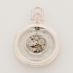 RELÓGIO, um (1) de algibeira (bolso), CÓPIA de relógio antigo, mostrador branco, com inscrição DECO, caixa em metal prateado, medindo 46 mm diâmetro, mecanismo a corda com 17 rubis, travado, duas tampas relevadas em alegorias Art Deco, tampa traseira solta e com rachados, vide foto.