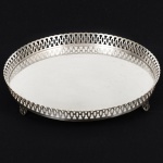 METAL PRATEADO, uma (1) salva circular, fundo liso, borda em gradil vazado, pés idem, sem marca de manufatura aparente, medindo 31 cm diâmetro, vide foto.