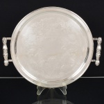 METAL PRATEADO, uma (1) bandeja circular, fundo em baixo relevo com pérgulas, volutas e elementos vegetalistas, alças em fumo de rolo, marca BELPRATA, medindo 36,5 cm diâmetro, vide foto.
