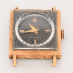 RELÓGIO, um (1) de pulso, marca MONDAINE (Mondaine Watch Ltd., relojoaria fundada em 1944, por Hans Hilfiker, em Zurique, Suíça), mecanismo a corda com 17 rubis ou safiras, parado, mostrador negro com algarismos arábicos, caixa em metal dourado, medindo 22 x 22 mm, falta a pulseira, usado, não testado e sem garantia, vide foto.