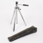 FOTOGRAFIA, um (1) tripé portátil, marca VIOLA, medindo fechado 27,5 cm, acondicionado em estojo com fechamento por zíper, confeccionado em metal cromado e outros materiais, vide foto.