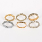 BIJUTERIAS, seis (6) alianças, modelos variados, confeccionadas em metal dourado e prateado, a grande maioria com cravações em pedras e/ou vidros facetados 8 x 8, tamanhos variados do 12 ao 18, uma delas elástica, vide foto.