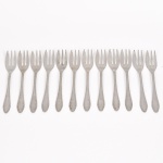 FAQUEIRO, doze (12) garfinhos para sobremesa, confeccionados em aço inox, ornados com frisos e volutas, marca EBERLE (Abramo Eberle 1880, Monte Magrè 1945, Caxias do Sul, veio com uma das primeiras levas de imigrantes italianos para o Brasil em 1884 junto com seus pais Giuzeppe Eberle e Luigia Zanrosso, seu pai abriu uma pequena funilaria mas como tinha que trabalhar na lavoura quem cuidava era a mãe e o pequeno Abramo ajudava na funilaria; em 1896 quando o pai resolveu vender a funilaria para concentrar os esforços da família na lavoura Abramo, com 16 anos de idade, se propôs a comprá-la do pai, em 1918 já com o nome Abramo Eberle & Cia iniciou a fabricação de talheres e utensílios de mesa, morreu em 1945 com 65 anos de idade e os filhos deram continuidade aos negócios até 1984 quando venderam para o Grupo Zivi), medindo 13,5 cm comprimento, vide foto.