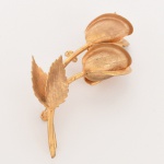 BIJUTERIA, um (1) broche representando flores, confeccionado em metal dourado, medindo 8 cm comprimento, vide foto.