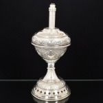 LUMINÁRIA, uma (1) base para abat-jour, para um lume, adaptada de antigo candieiro, relevada em escudos, volutas e elementos vegetalistas, montada sobre suporte em madeira, parte elétrica cerceada, medindo 35,5 cm altura, vide foto.