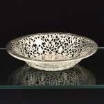METAL PRATEADO, uma (1) fruteira com borda vazada em silhuetas vegetalistas, medindo 22,5 cm diâmetro e 4,5 cm altura, sem marca de manufatura aparente, vide foto.